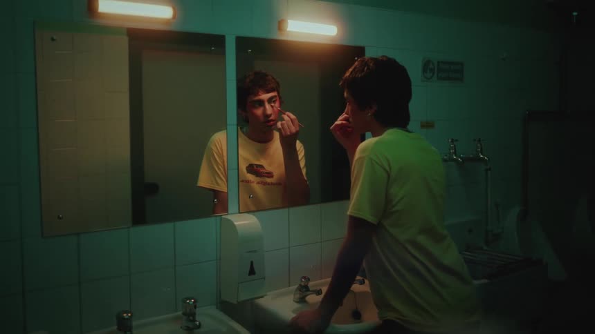Person in front of mirror in bathroom putting on makeup