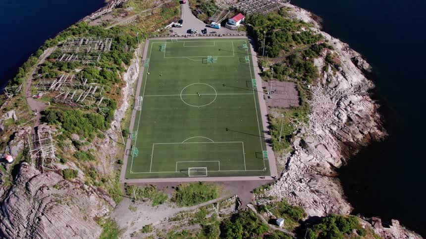 Aerial view of a soccer field on an island surrounded by sea