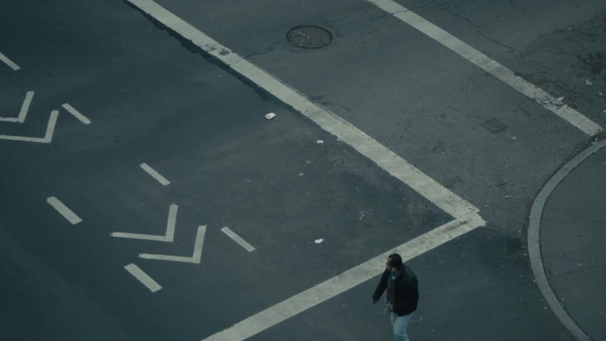 A man walks across the street during the day