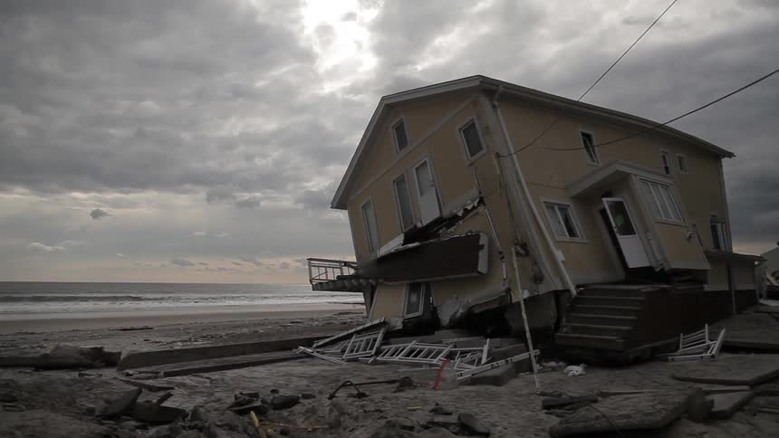 A dilapidated house in front of an ocean