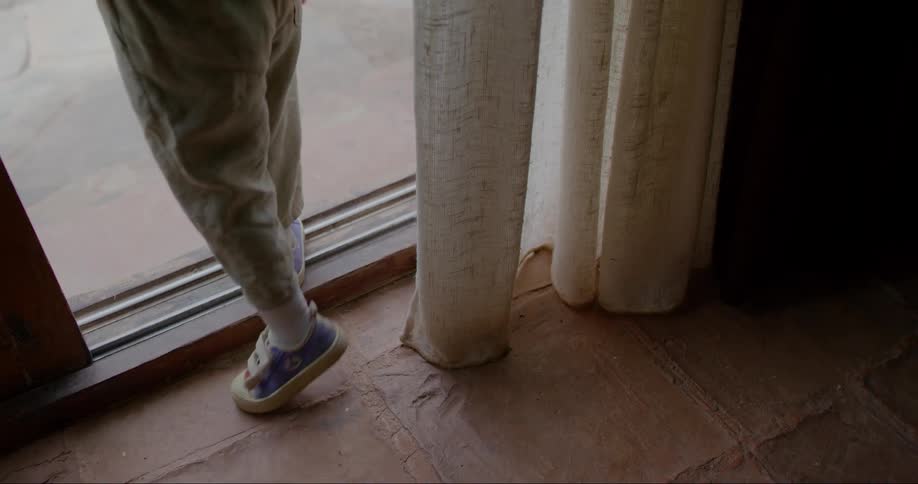 Child pauses in the doorway before walking outside