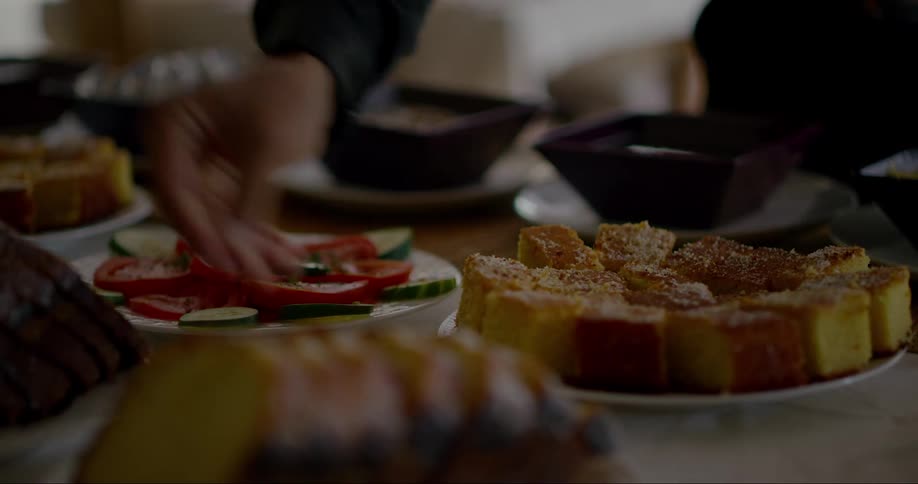 Woman sets dishes with food onto a flat surface at home