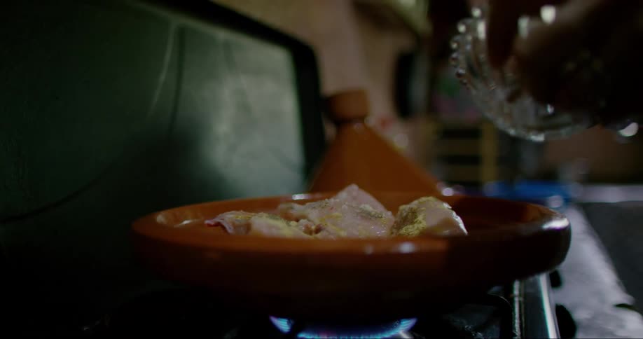 Person with a spoon pouring seasoning on top of meat