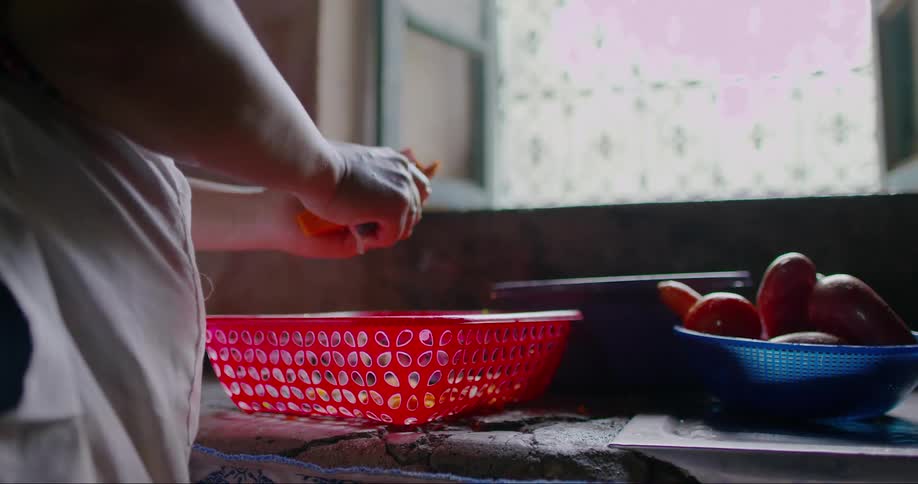 Hands of a woman with a knife cutting vegetables