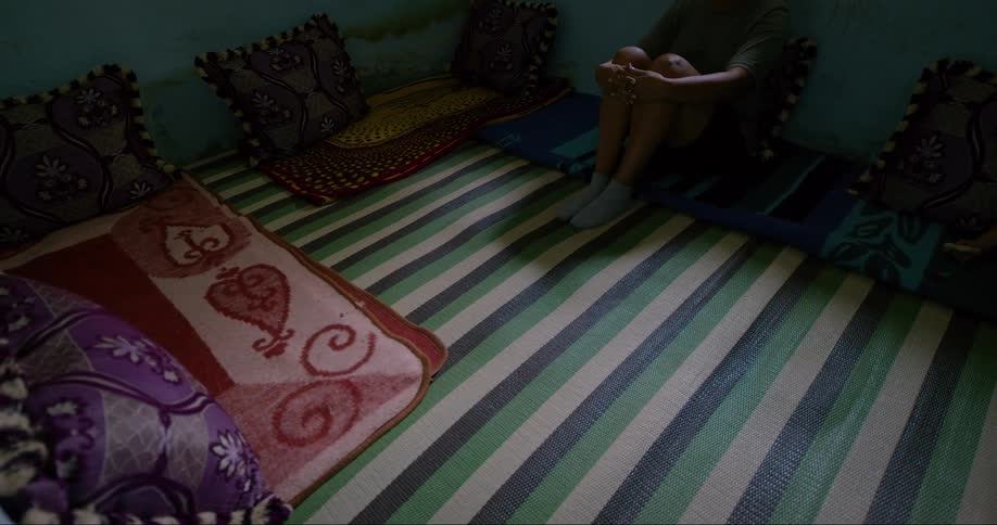 Woman sitting on a mat on the floor taps her feet