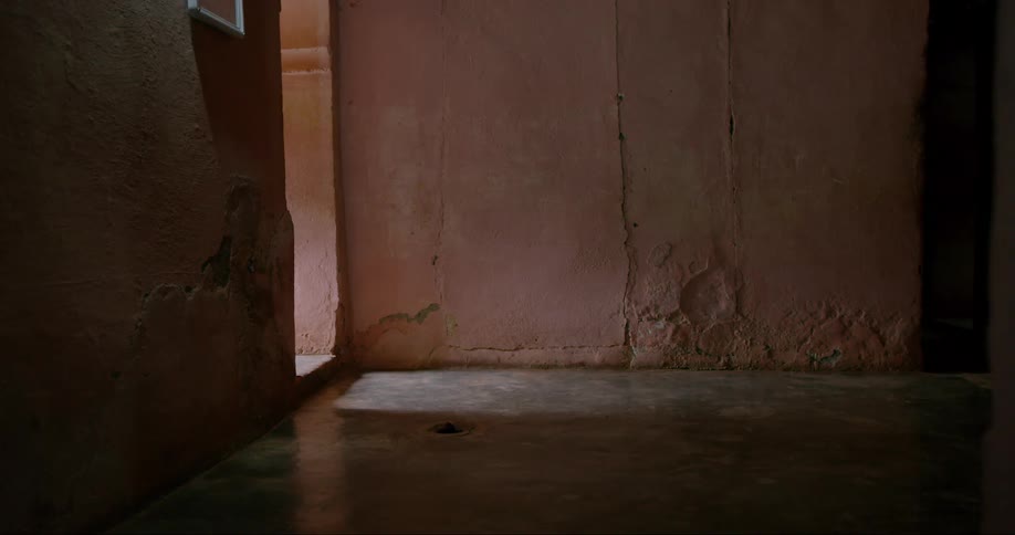 A woman walks through a dark hall