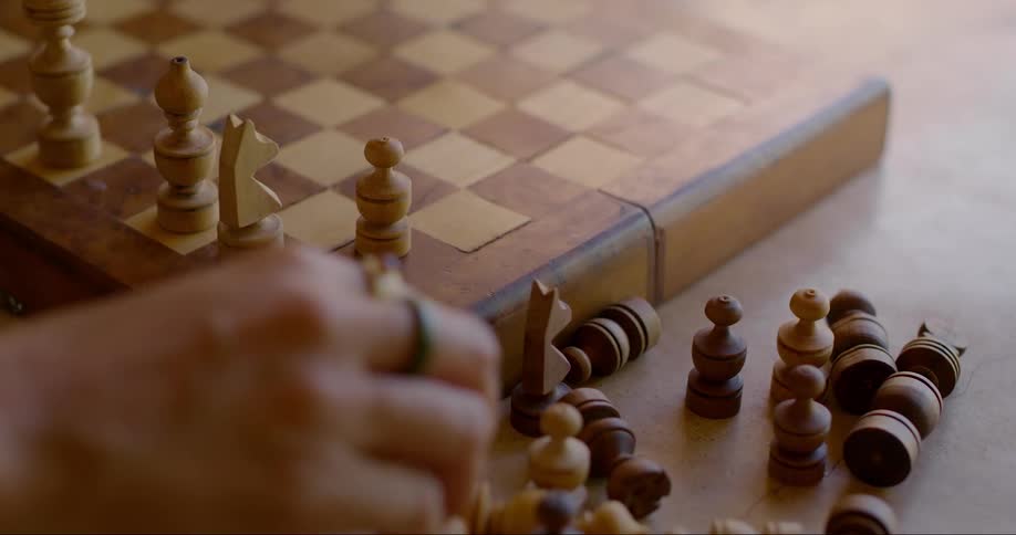 Hand placing pieces on a chessboard