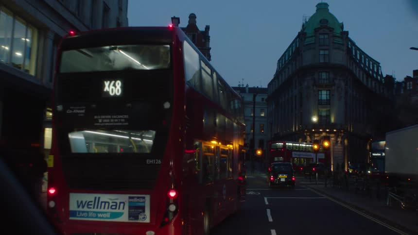 Heavy traffic of buses and vehicles on London streets at night