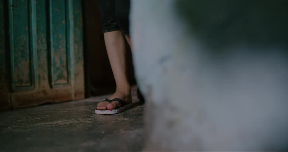 Two women stand together in a hallway before walking off