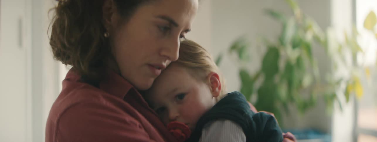 A mother hugs her child and bounces him around in her arms