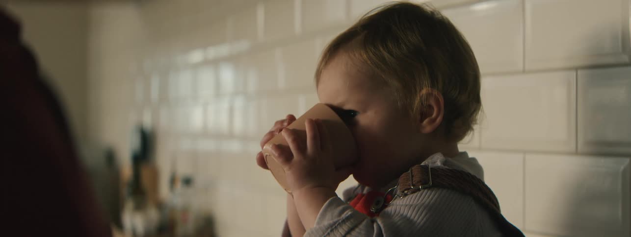 Little girl sitting drinking from a mug