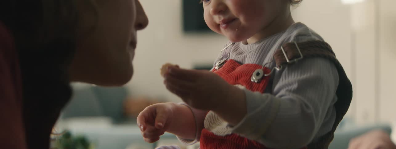 Child sitting eating and talking with mother