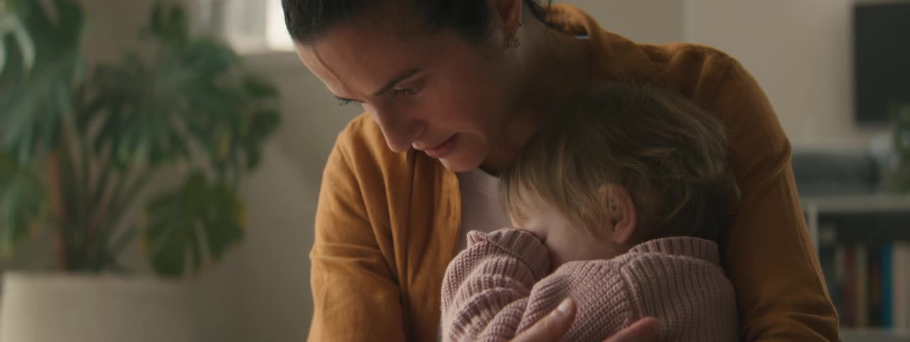 Mother sitting with her little daughter on her lap