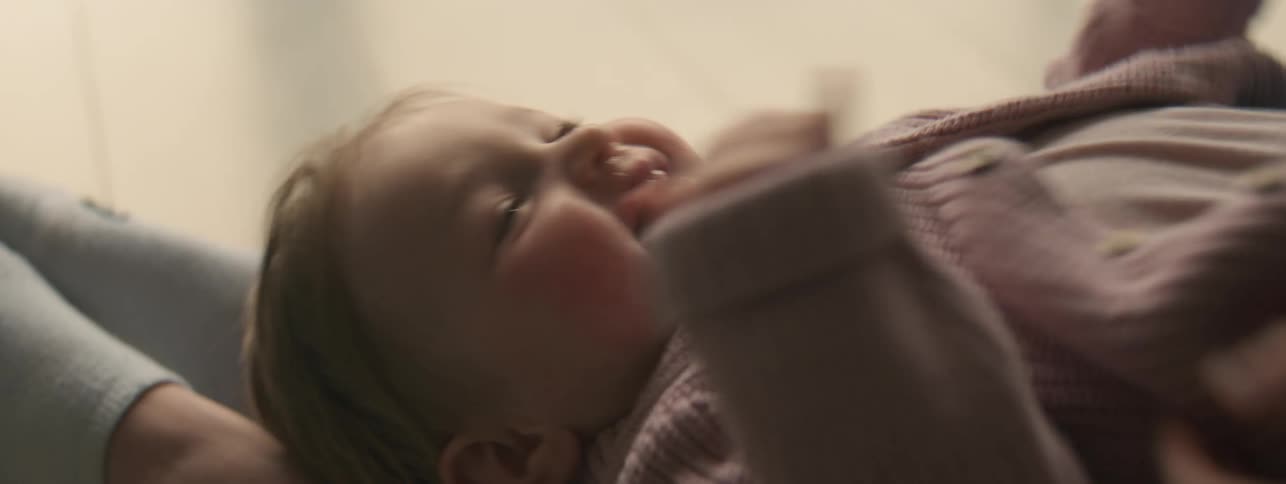 Mother tickles her baby on her lap