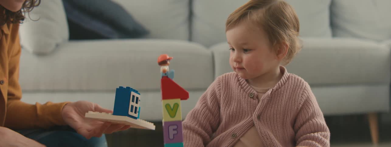 Mother playing and interacting with toys together with her little daughter