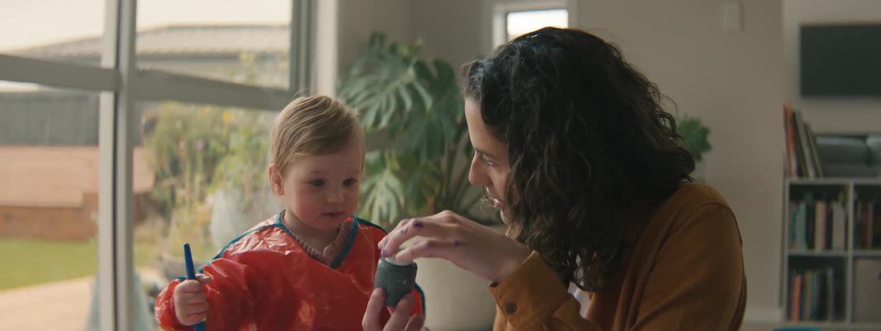 Mother playing with paint with her little daughter