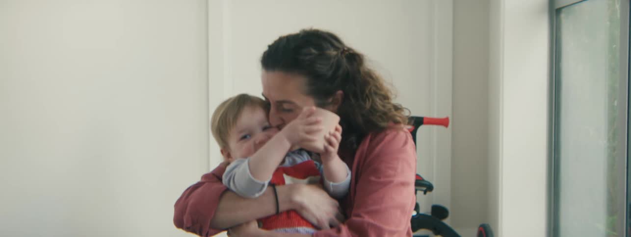 Mother laughing and hugging her little daughter