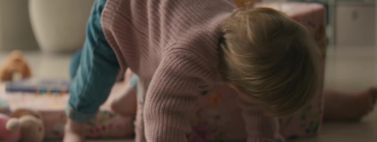 Mother sitting with her little daughter who stands up