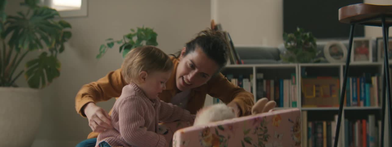 Mother playing teddy bear with her little daughter