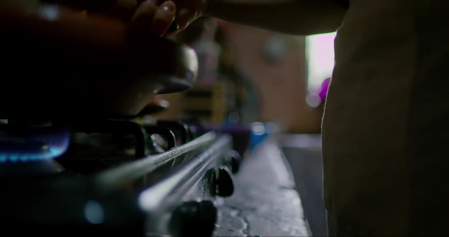 Close up of a person cooking on the stove
