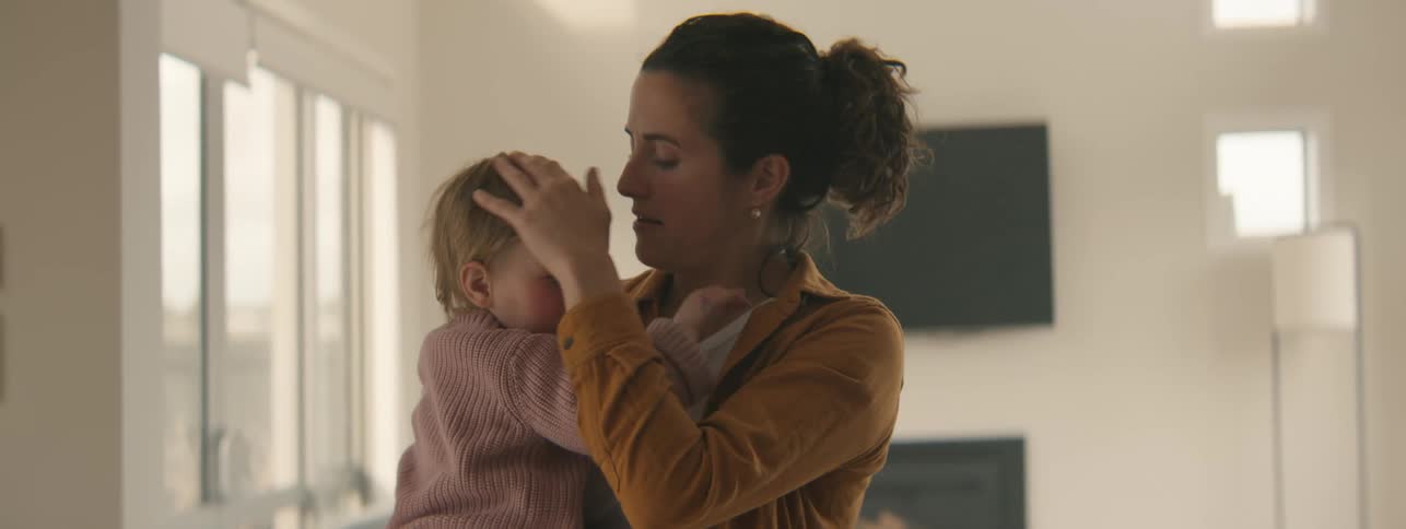 Mother standing with her little daughter on her lap