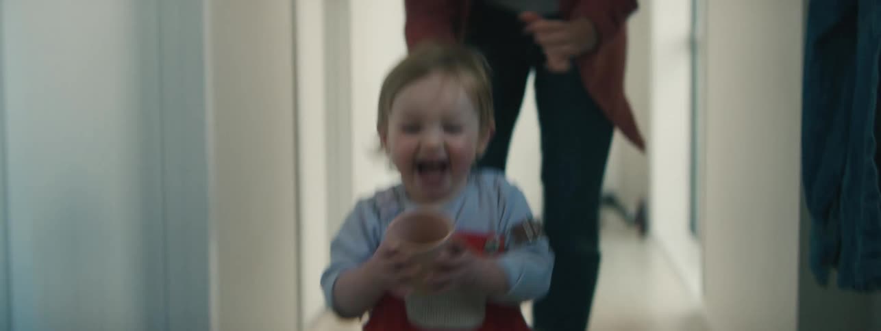 Child running down a hallway and her mother following behind her hugging her