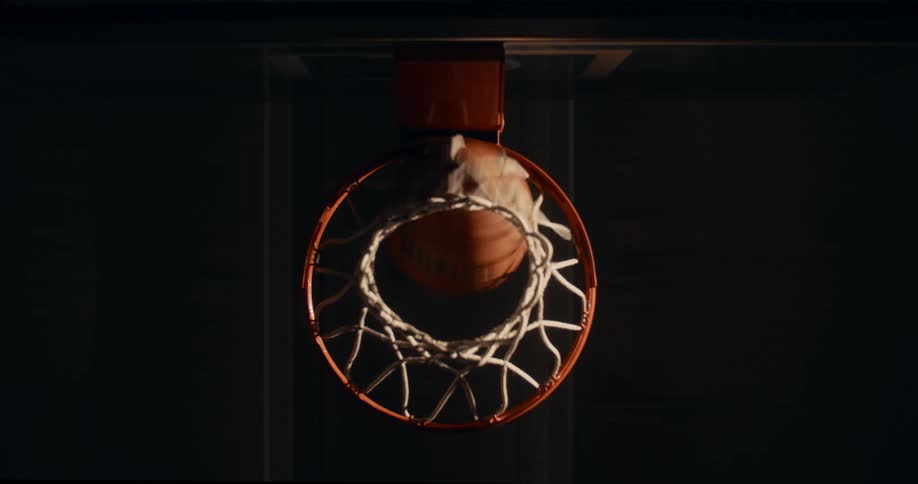 A basketball passing through a hoop net