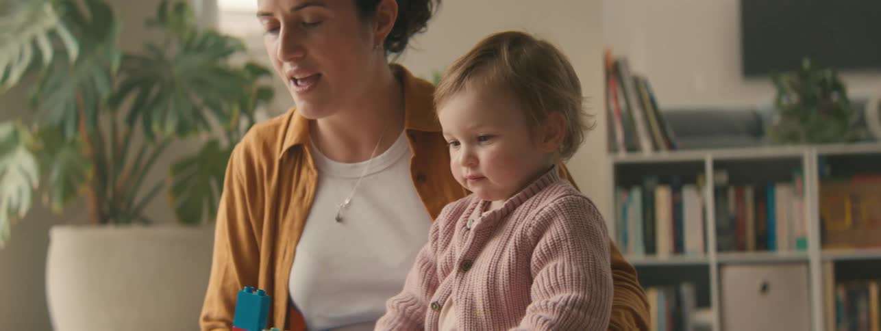 Mother playing blocks with her daughter holds onto her patience when the child throws a block
