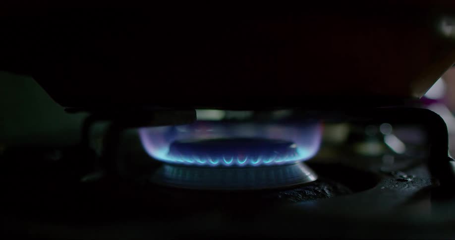 Closeup of a lit stove with a pan on top