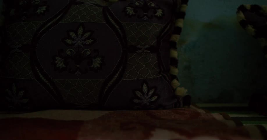 Shadow of a person standing next to a pillow and blanket