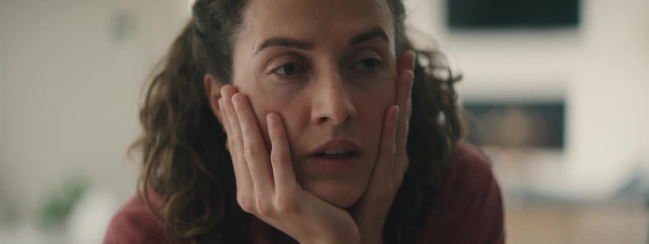 Tired woman with curly hair showing stress and exhaustion.