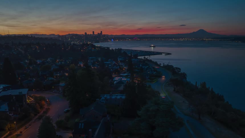 The Magnolia neighborhood slowly comes to life at sunrise as a vibrant sky glows behind Seattle and Mt. Rainer