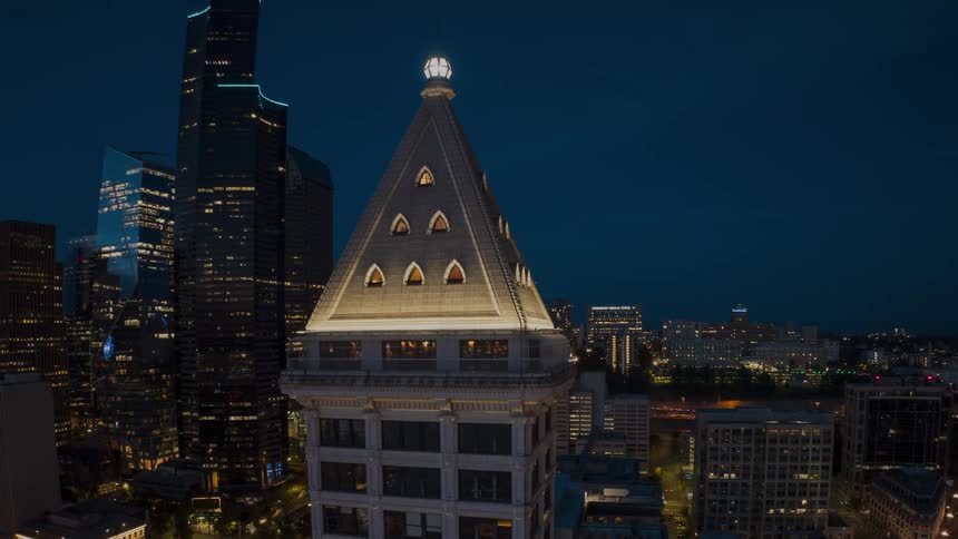 Dynamic orbit around the top of Smith Tower as the lights of downtown Seattle shine brightly
