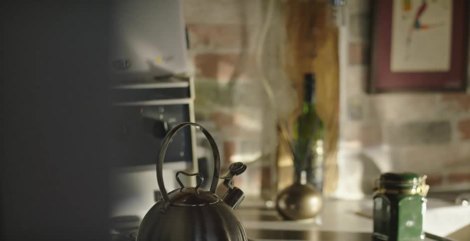 Steam rises from a kettle on a stovetop at home