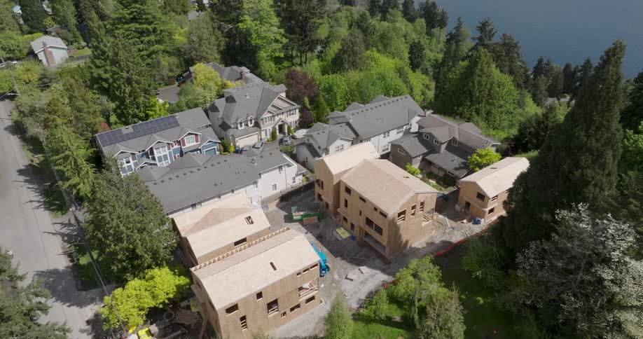 Pullback reveal of a lakeside neighborhood where new townhomes are under construction