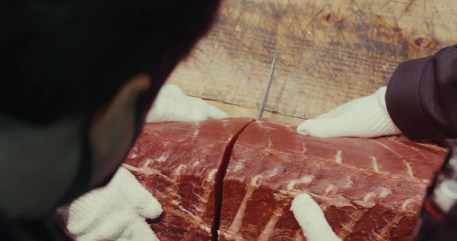 A clip of people cutting a fish in a fish processing factory
