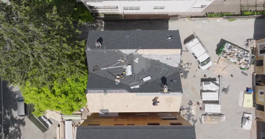 Roofers work on a brand new townhome in a new residential development