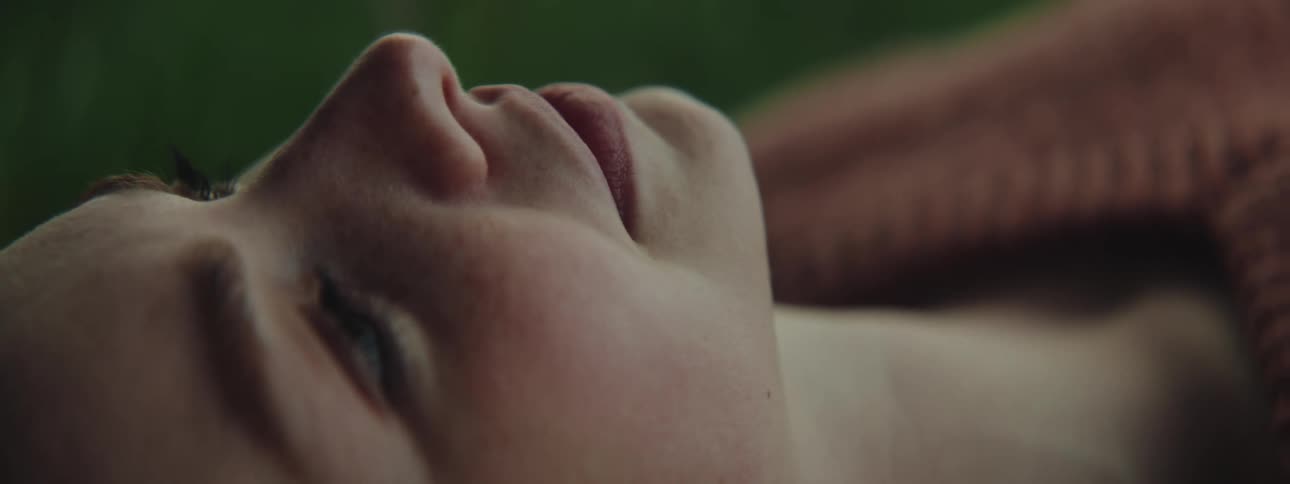 Closeup of a beautiful redhead womans face resting on a yellow blanket