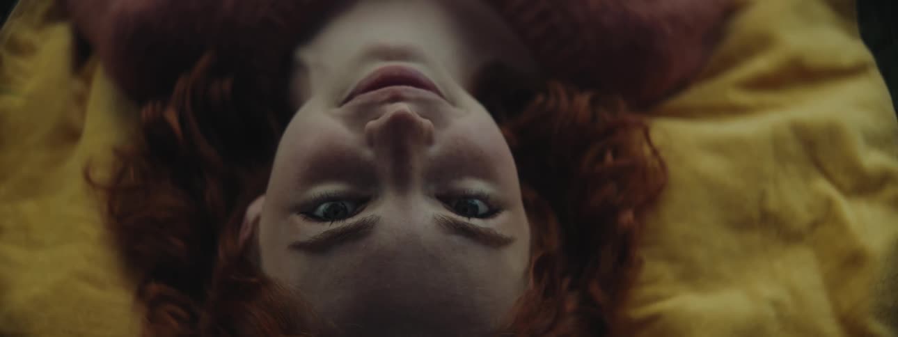 Portrait of a redhaired woman lying on a yellow cloth