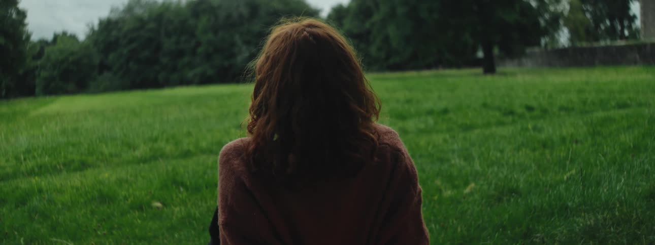 A clip of a lady sitting on a plain grass