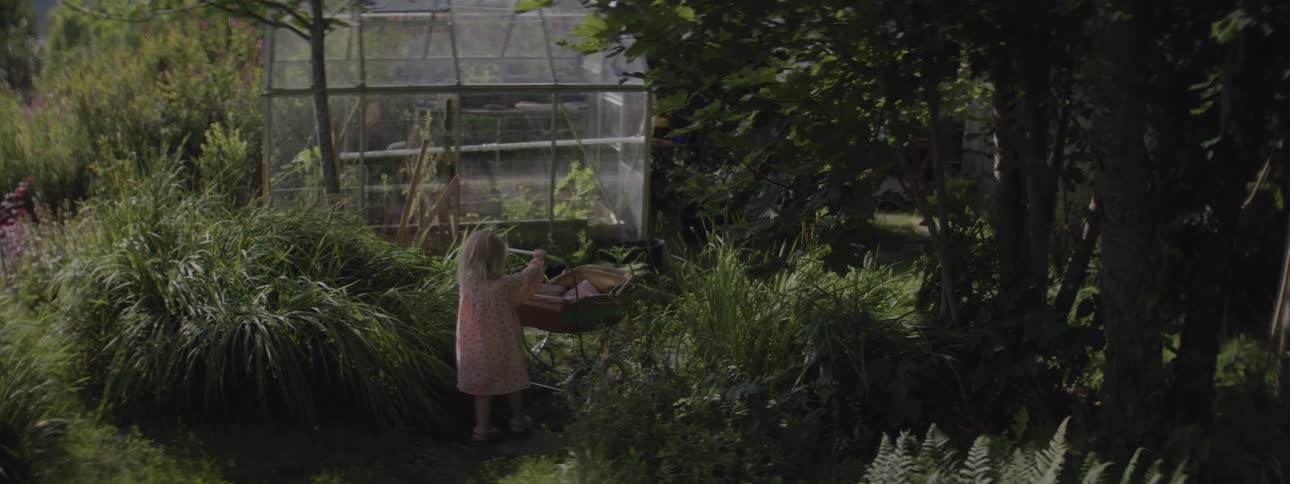 Awoman pushes a cart through a forest
