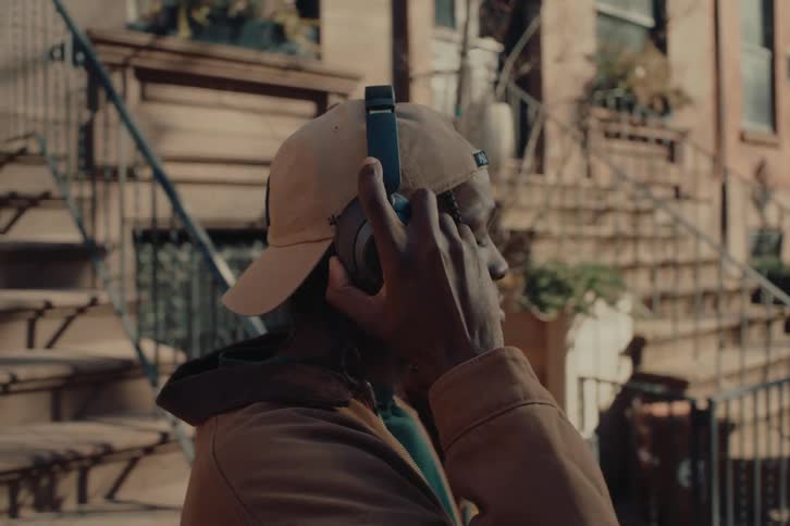 Man with backwards cap putting on black headphones