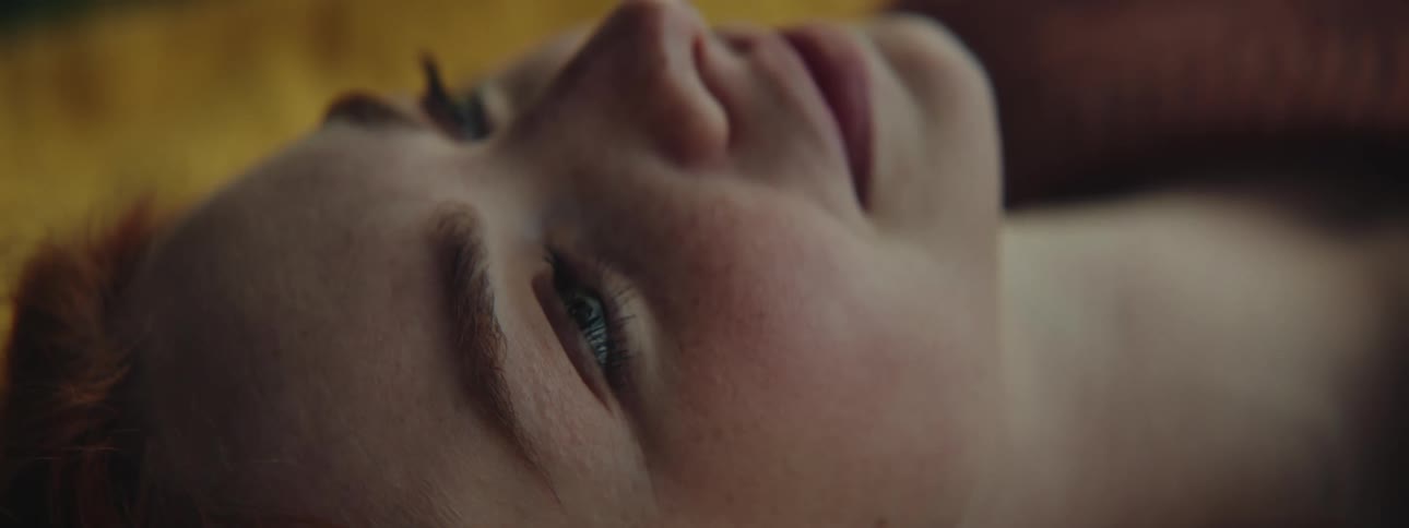 Closeup of a beautiful redhead womans face resting on a yellow blanket