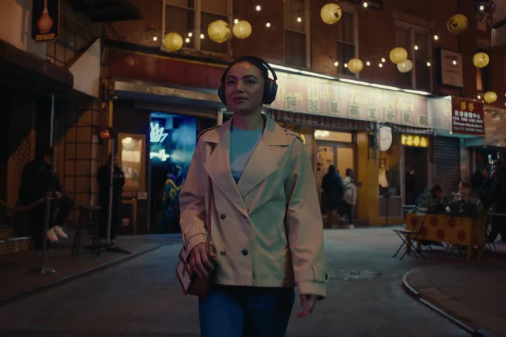 A woman is walking through the city at night