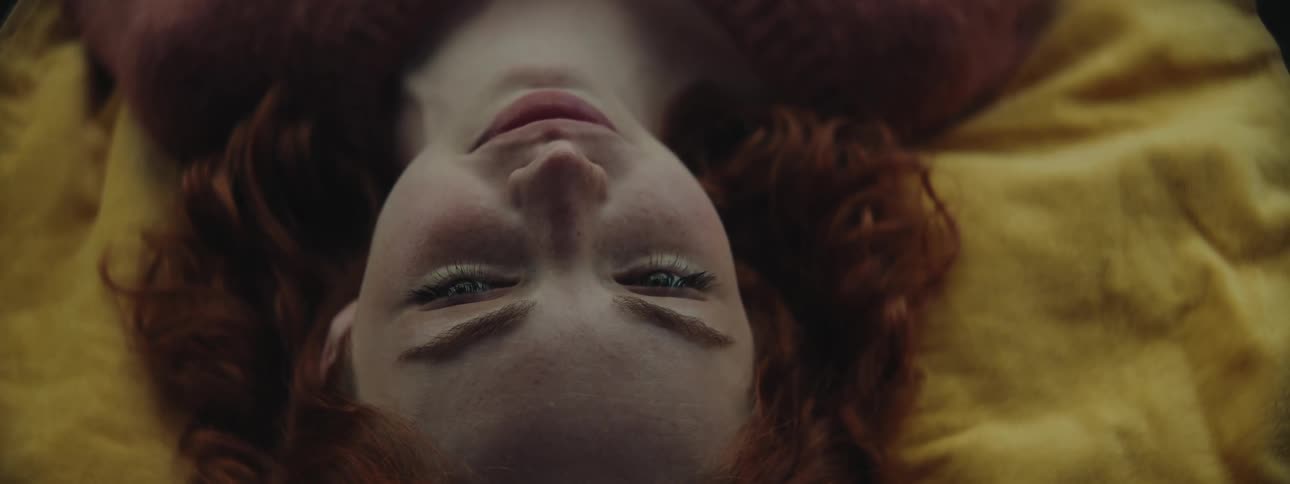 Portrait of a redhaired woman with curly hair lying down