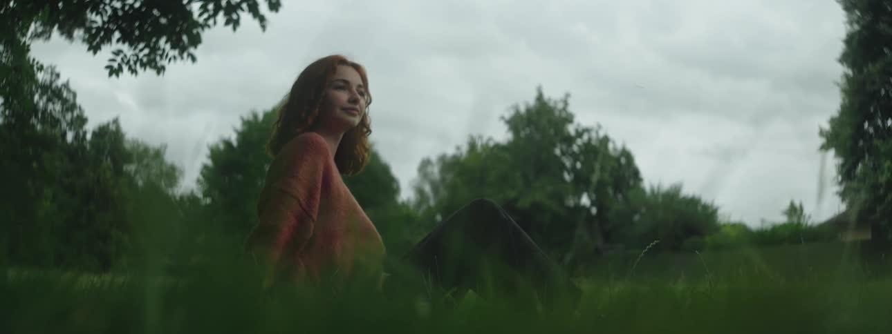A woman is siting in the woods
