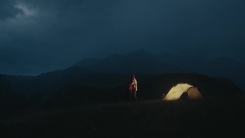 Two people are camping at night