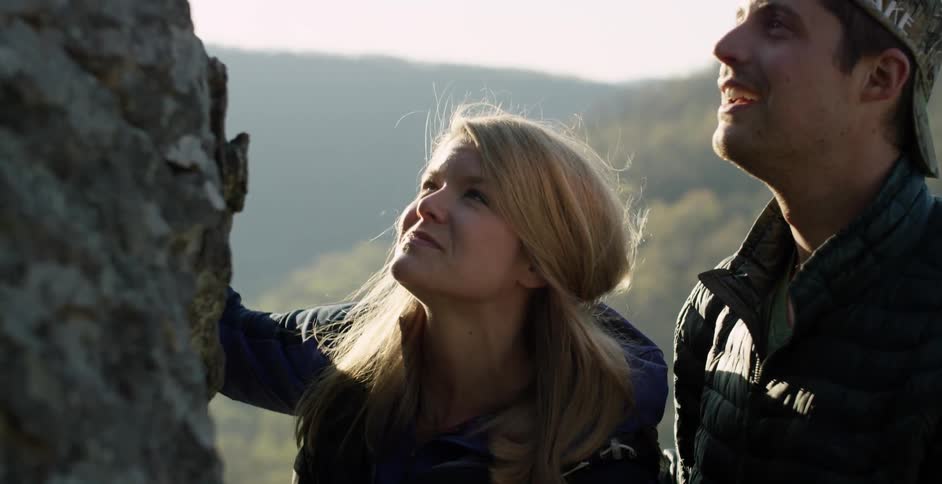 Man and woman admiring a large rock that is before them