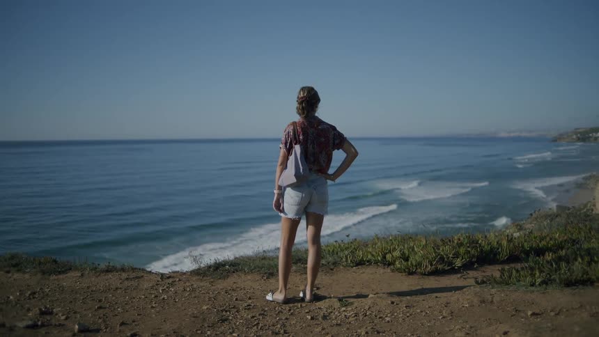A woman is looking out over the coean