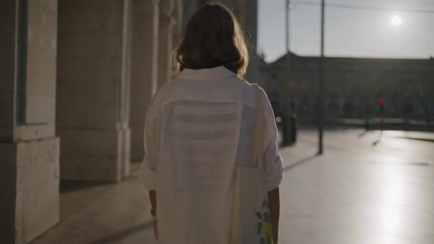 A back view of a lady walking on the street